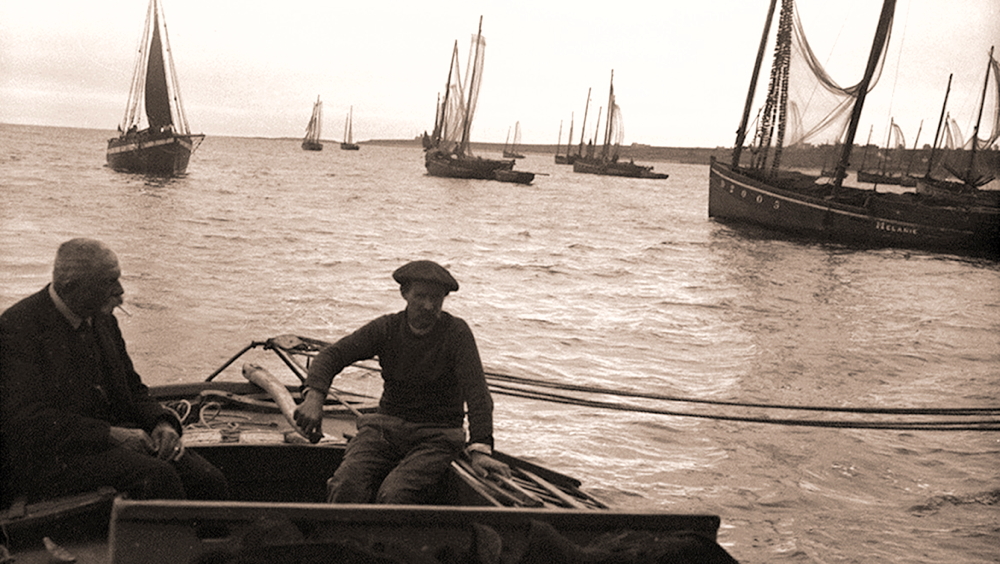 Source : photo communiqué par Jean-Jacques Le Lons. Une photo de Jacques de Thézac, vers 1913, avec le DZ 2005. Pierre Quéméré, matelot de Jacques de Thézac, est à la barre du yacht «Pen Huel» en compagnie d'Henri Gallice de l’Île de Sein