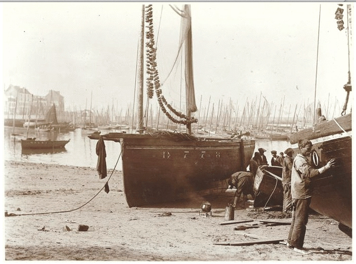 Source : Photographie de Charles Lhermitte (RMN Musée d’Orsay), découverte par A. Le Coz. La chaloupe Etoile de la Mer au calfatage sur la plage du Stigadou, vers 1912.